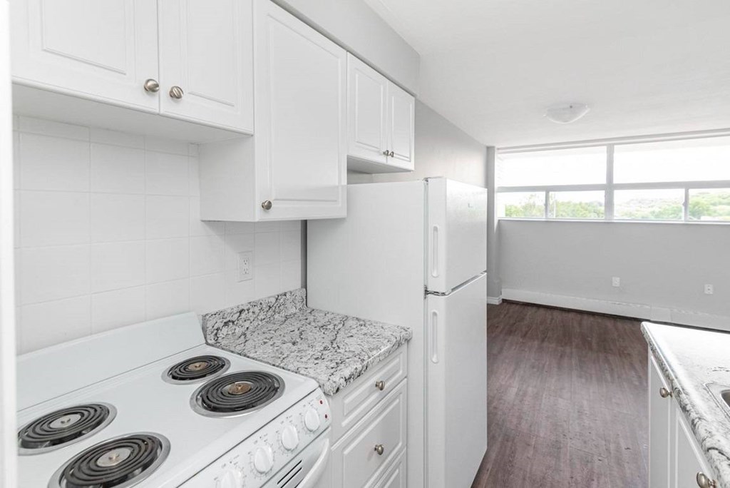 A kitchen with white cabinets and a granite countertop.