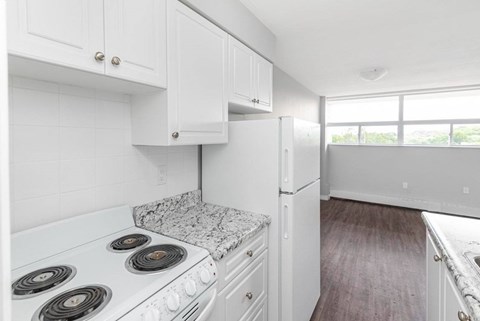 A kitchen with white cabinets and a granite countertop.