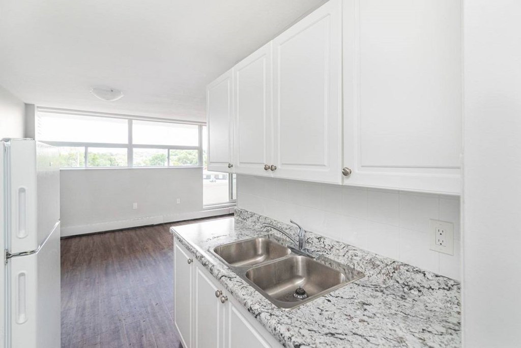 A kitchen with a granite countertop and white cabinets.