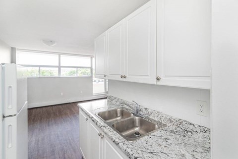 A kitchen with a granite countertop and white cabinets.