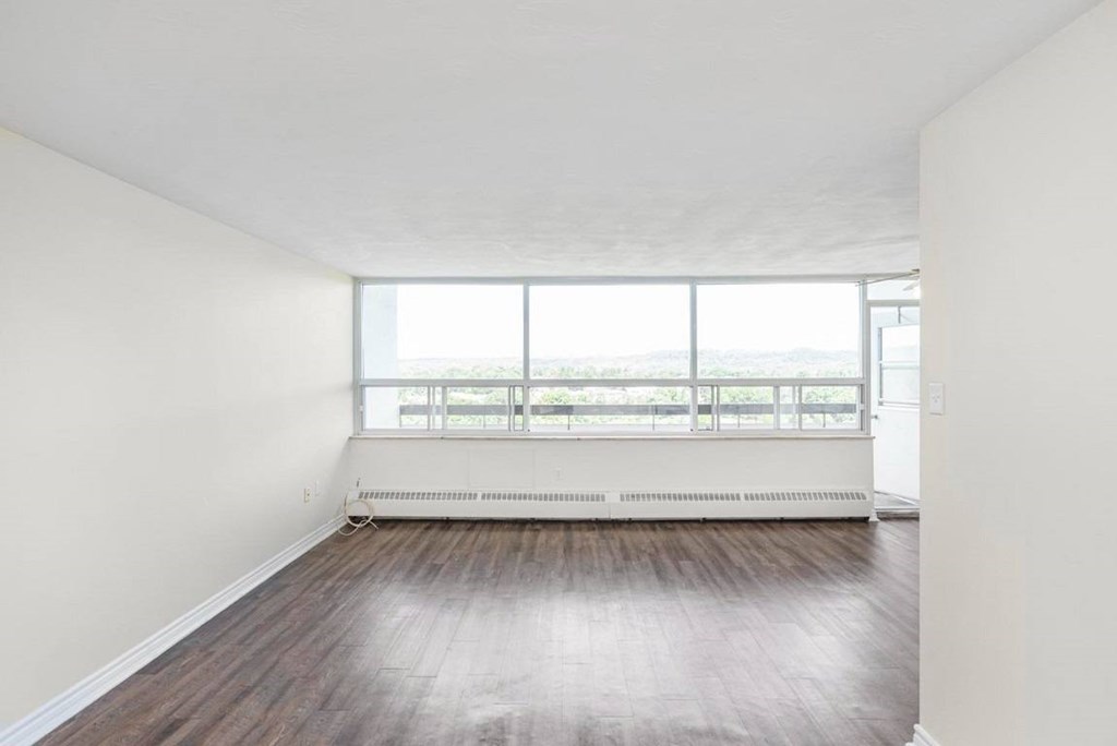 A room with a window and a radiator on the floor.