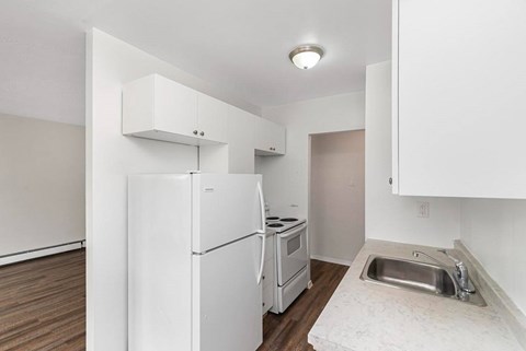 A kitchen with white appliances and a sink.