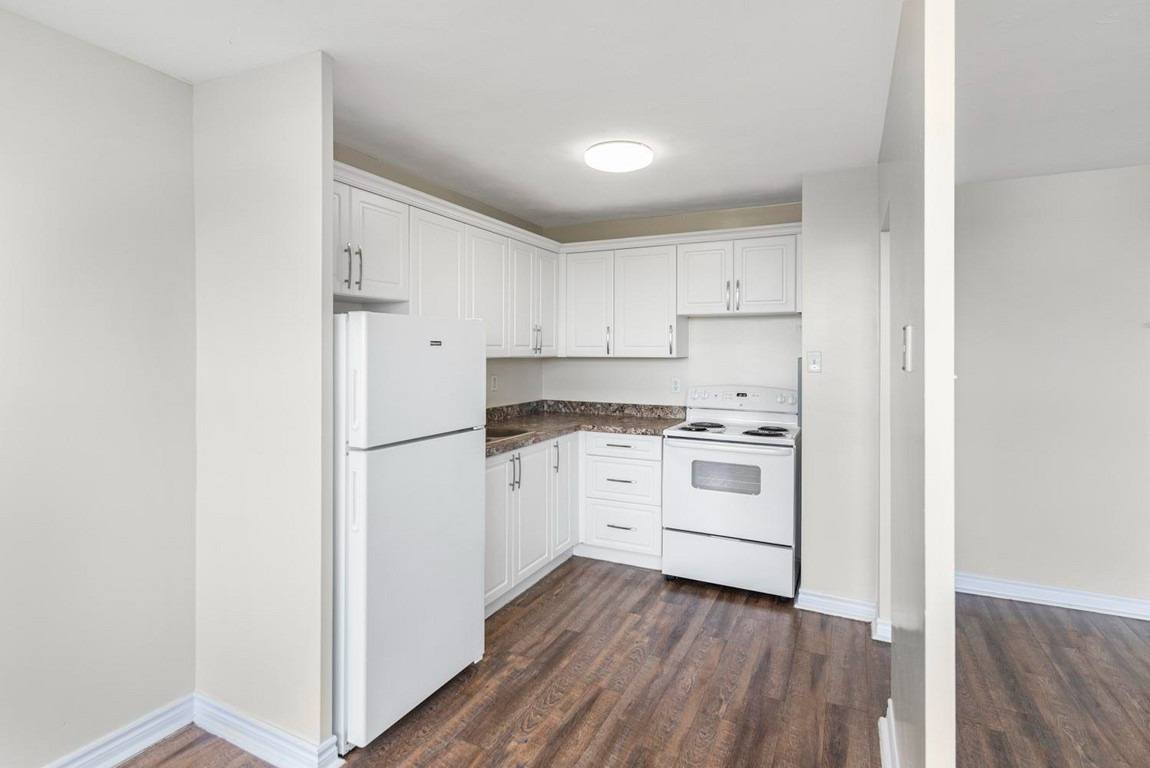 A kitchen with white appliances and cabinets.