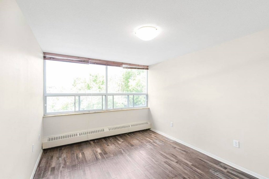 A room with a window and a radiator on the wall.