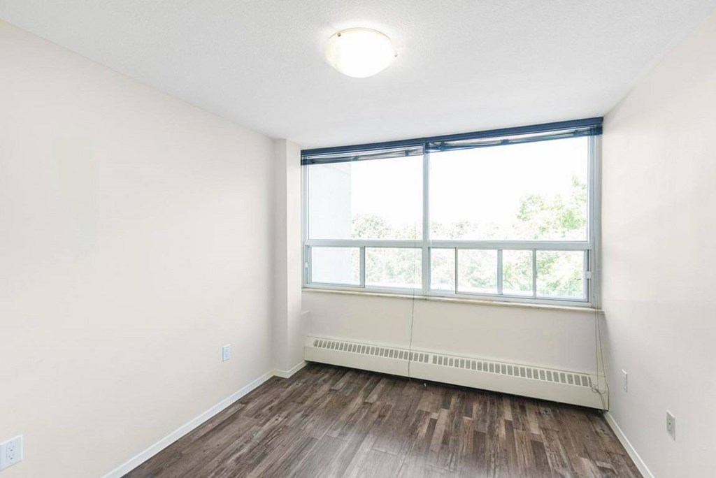 A room with a window and a radiator on the wall.