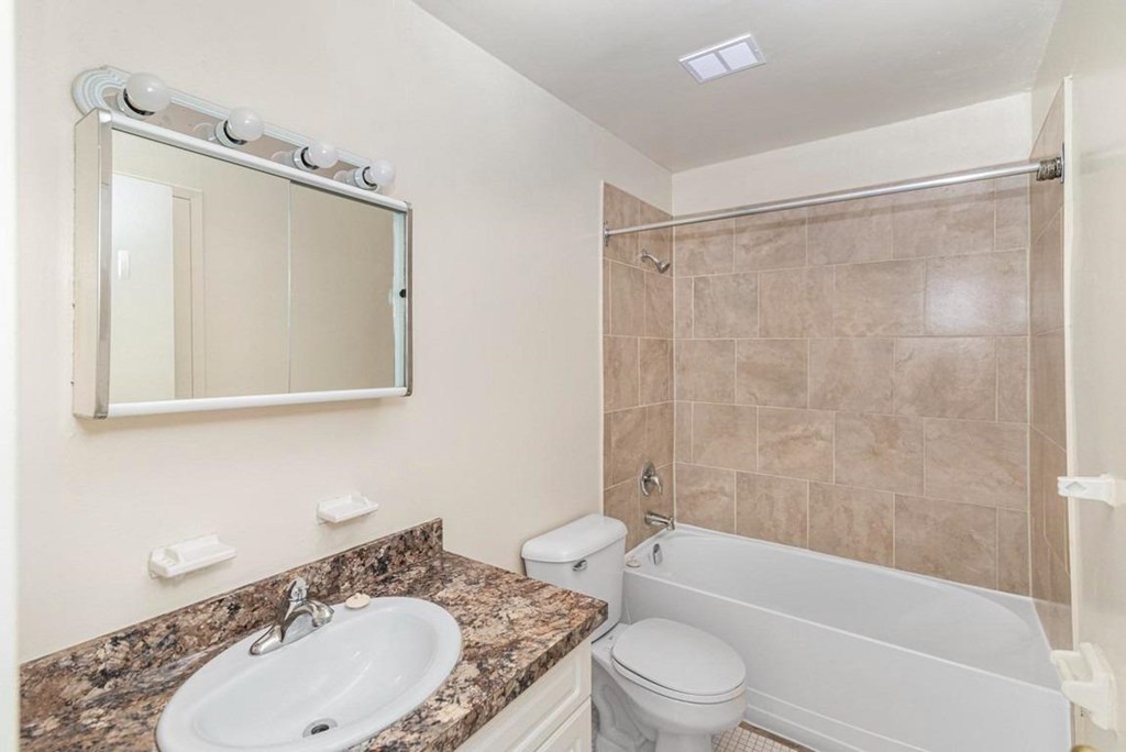 A bathroom with a sink, toilet, and bathtub.