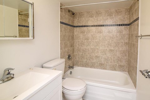 A bathroom with a toilet, sink, and bathtub.