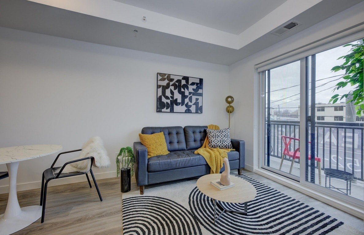 A living room with a grey couch and a yellow throw.