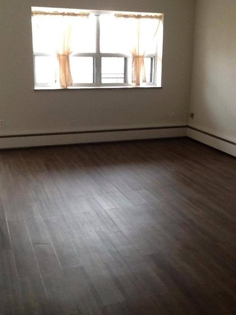 A room with a window and wooden flooring.