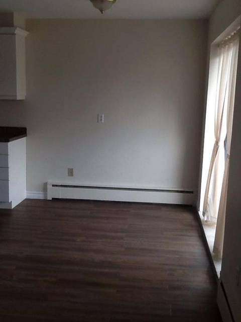 A room with wooden floors and white walls.
