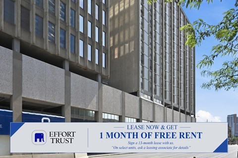 A large building with a sign offering a free month of rent.
