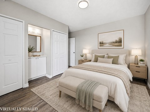 A bedroom with a large bed and a painting on the wall.