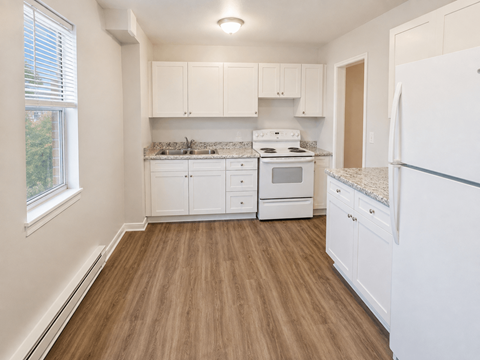 A kitchen with white appliances and cabinets.