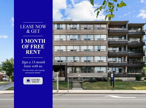 A large building with a blue sign offering free rent for the first month.