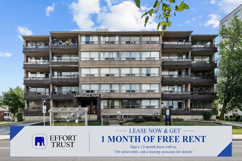 A multi-story apartment building with a sign offering a free month of rent for 13-month leases.