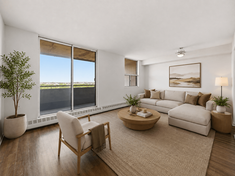 A living room with a large window, a sofa, a chair, a coffee table, and a potted plant.