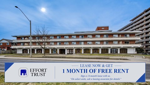 A large building with a sign offering a free month of rent.