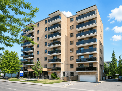 A large apartment building with balconies on the second floor.