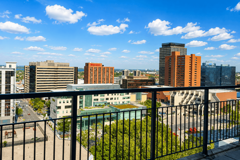 A cityscape with buildings of various heights and a clear blue sky.