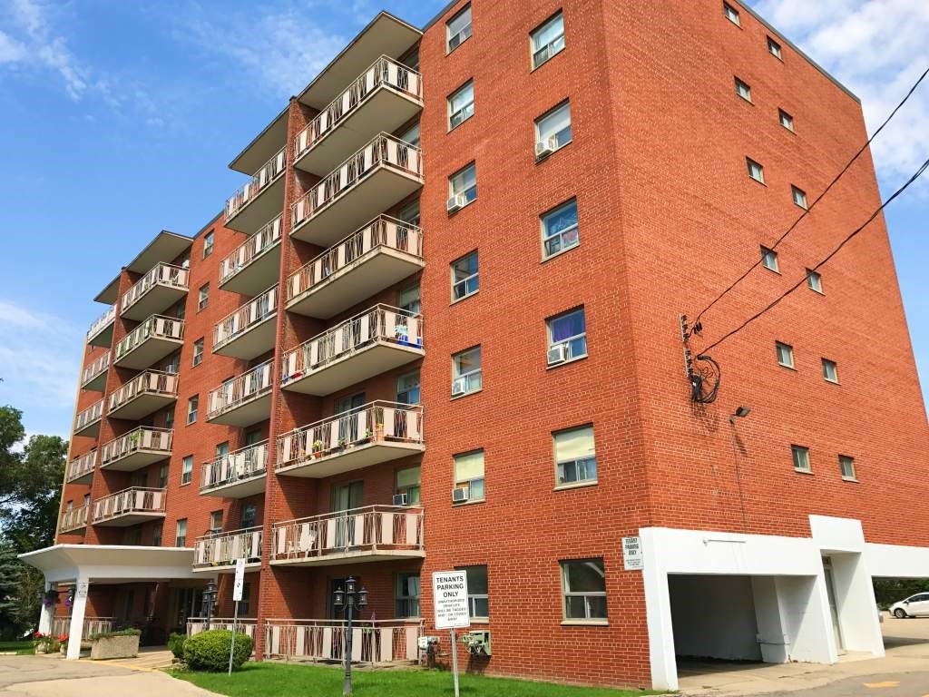 A red brick apartment building with a white garage door.