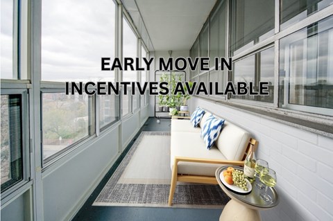 A room with a tray of food on a table and a couch with a pillow and a blanket on it.