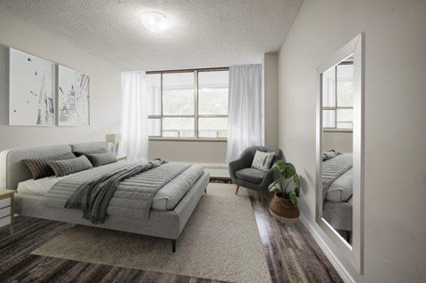 A bedroom with a large bed and a chair.