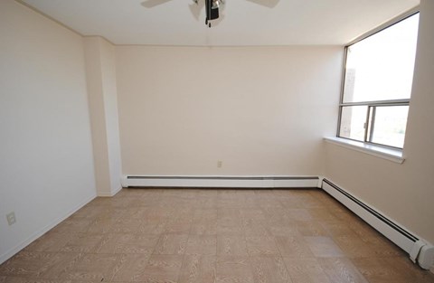 Empty room with a ceiling fan and a window.