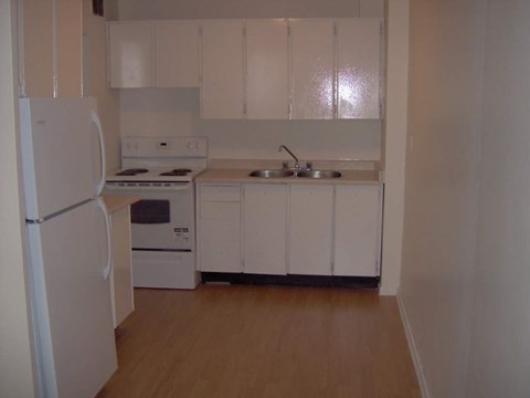 A kitchen with white appliances and cabinets.