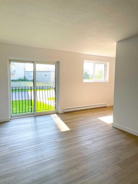 A room with a sliding glass door leading to a green outdoor area.
