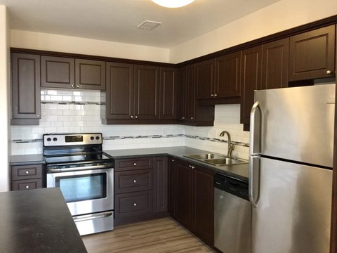 A kitchen with dark brown cabinets and stainless steel appliances.