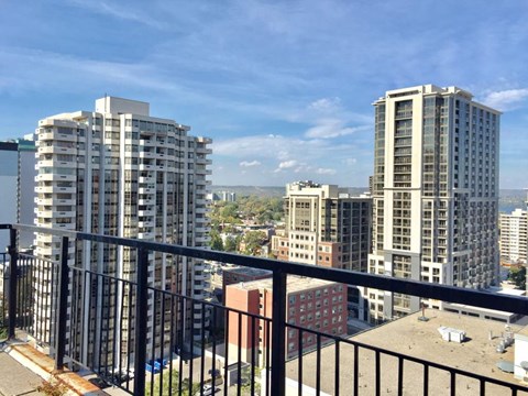 A cityscape with buildings and a balcony in the foreground.