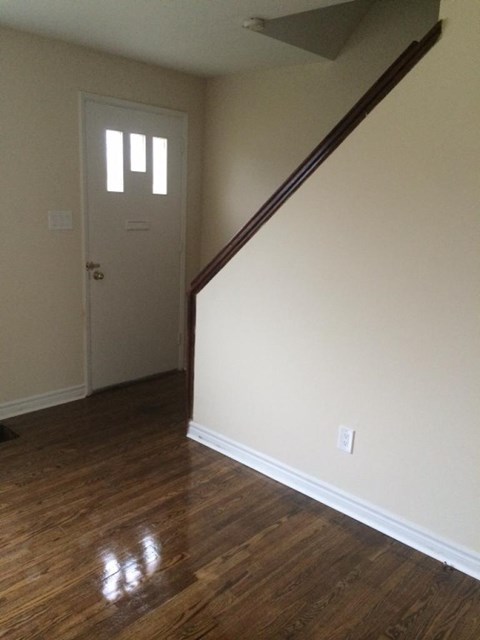 A room with a wooden floor and a white door.