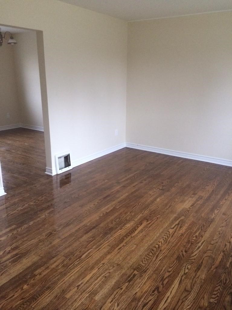 A room with wooden flooring and a white wall.