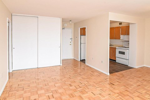 A kitchen with white appliances and wooden floors.
