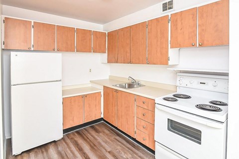A kitchen with wooden cabinets and white appliances.