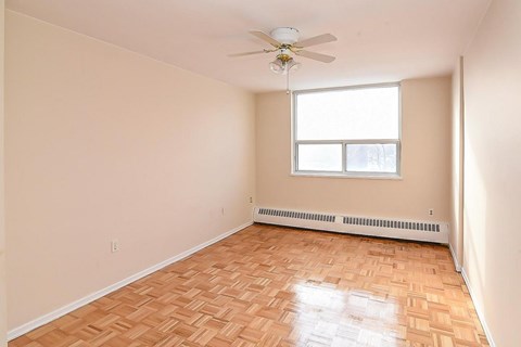 A room with a ceiling fan and a window.