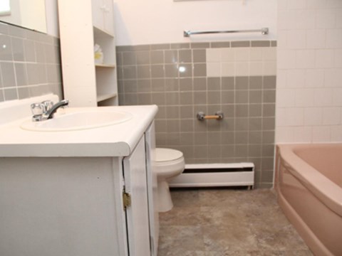A bathroom with a toilet, sink, and bathtub.
