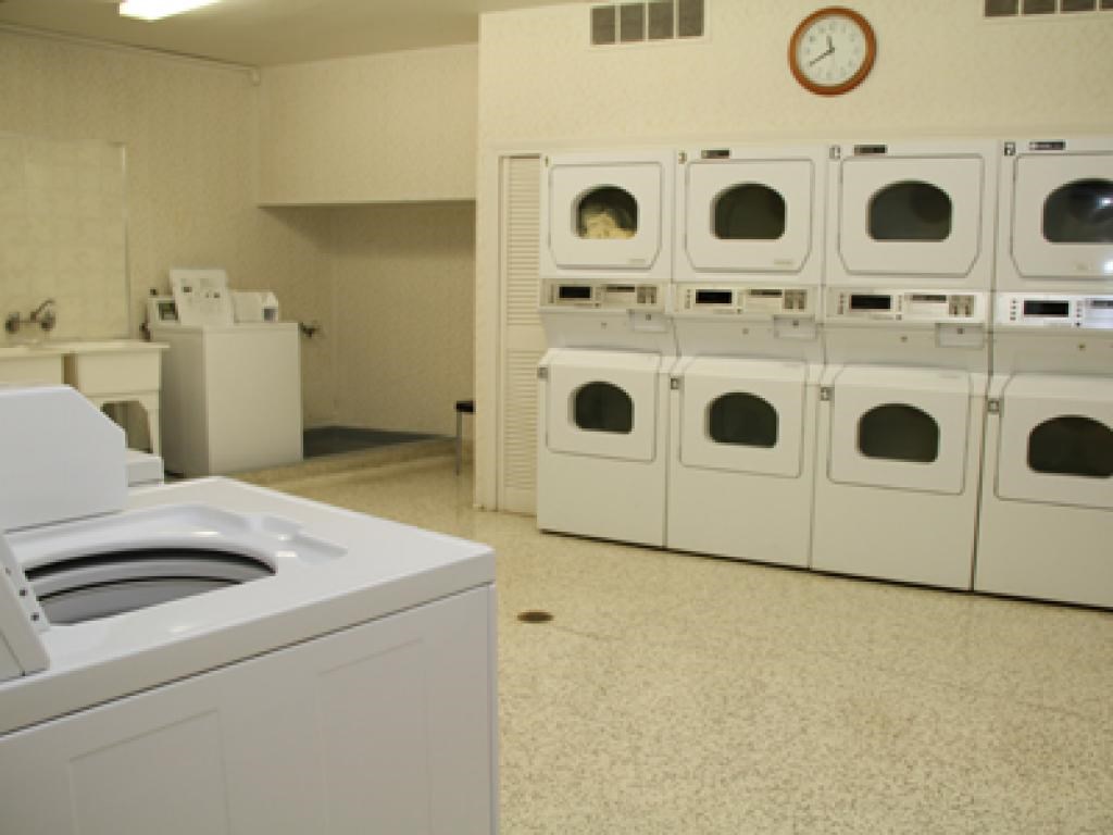 A row of white washing machines in a laundromat.