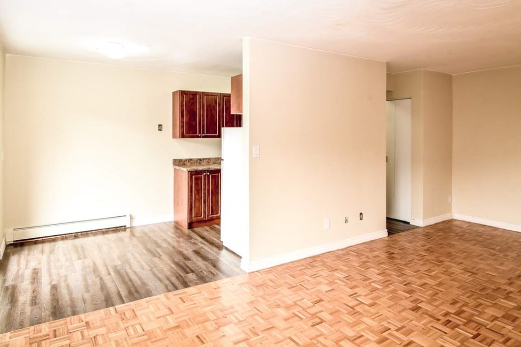 A room with wooden flooring and a fireplace.