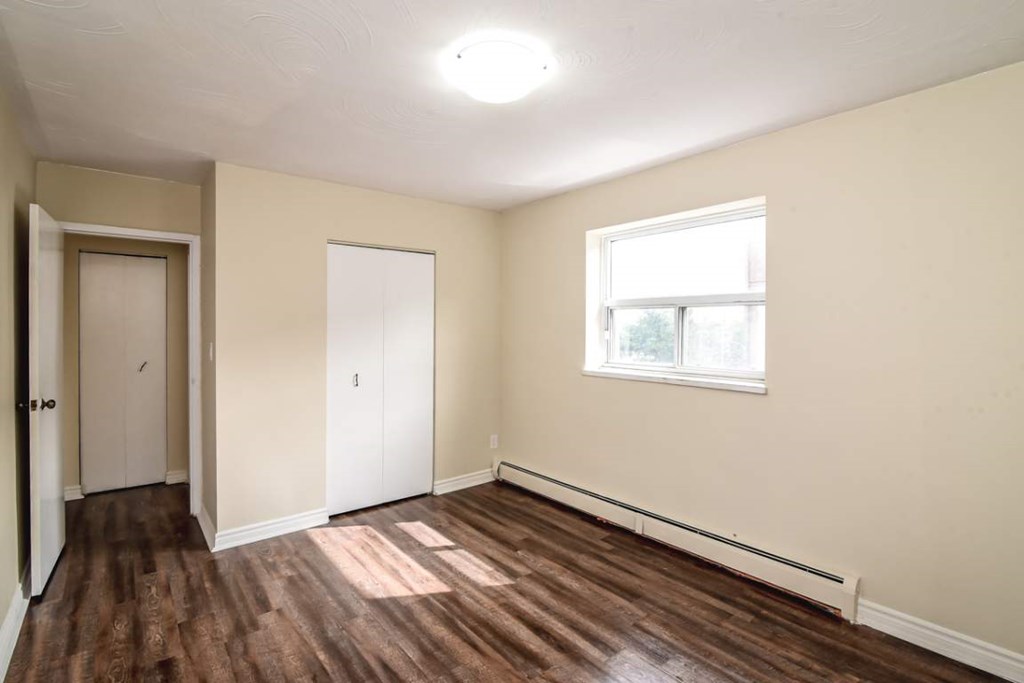 A room with a window and wooden floors.