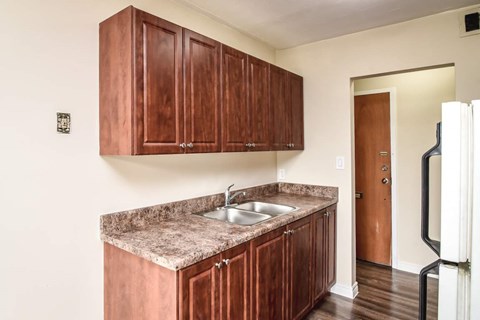 A kitchen with brown cabinets and a granite countertop.