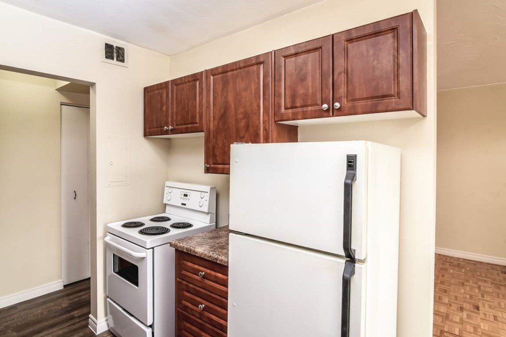 A kitchen with a white refrigerator, stove, and oven.