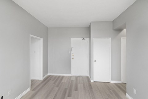 A room with three doors and a grey floor.