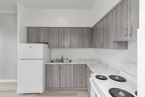 A kitchen with a white stove top oven and a white refrigerator.