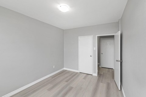 A room with a light grey wall and a wooden floor.