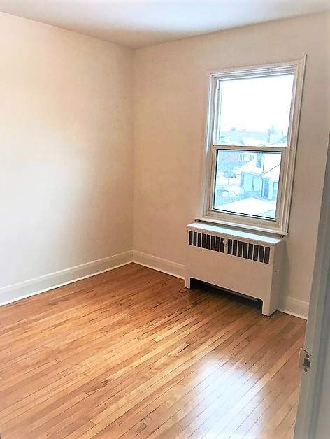 A room with a window and a radiator on the wall.