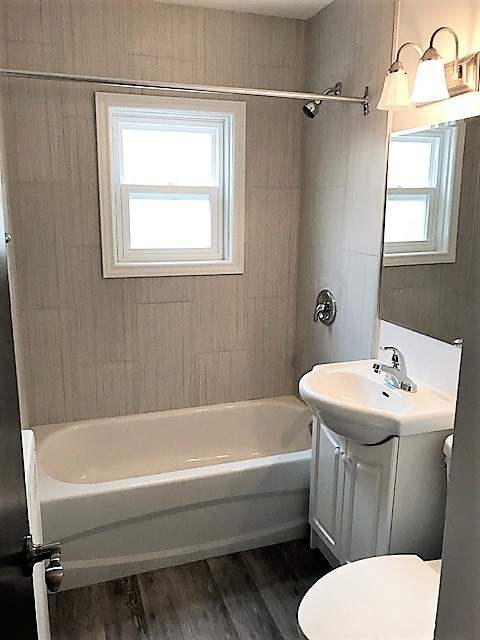 A white toilet sits next to a sink in a bathroom.