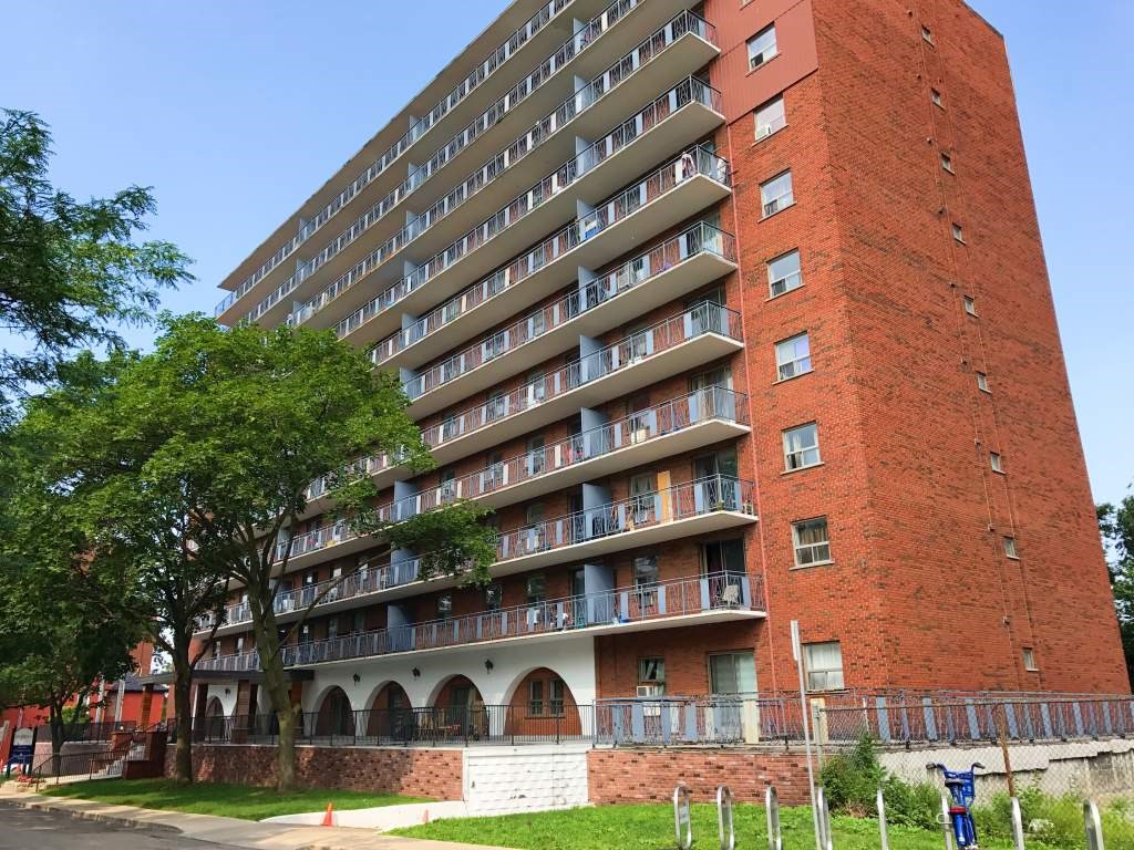 A red brick building with balconies and windows.