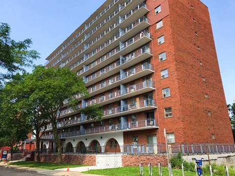A red brick building with balconies and windows.