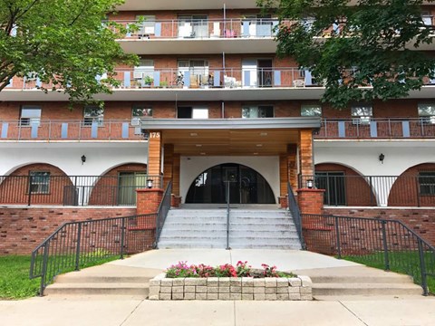 A building with a red brick wall and a black railing.
